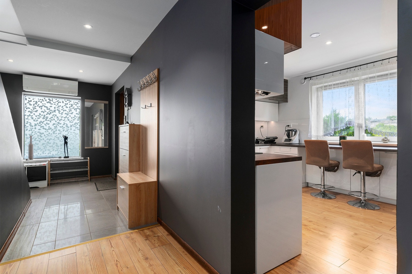 En romslig gang ønsker deg velkommen, med praktiske løsninger for oppbevaring av sko og klesoppheng. Galleribilde