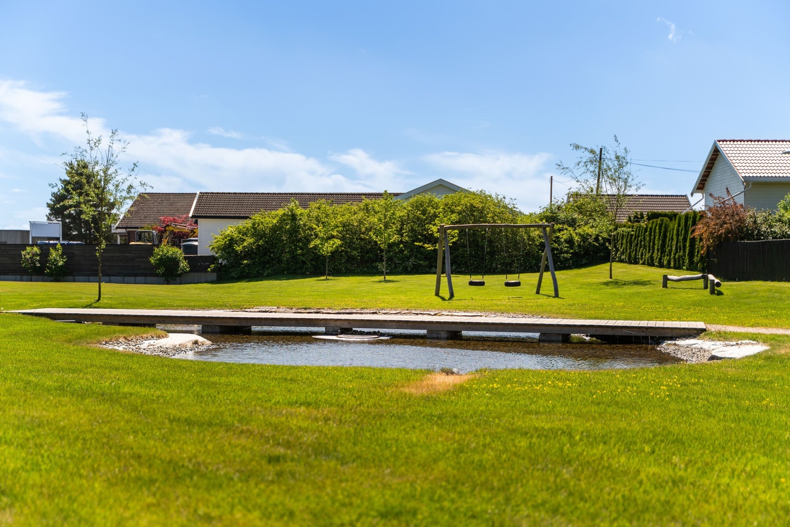 Borettslaget har pent opparbeidet uteområde med vannspeil og husker. Galleribilde