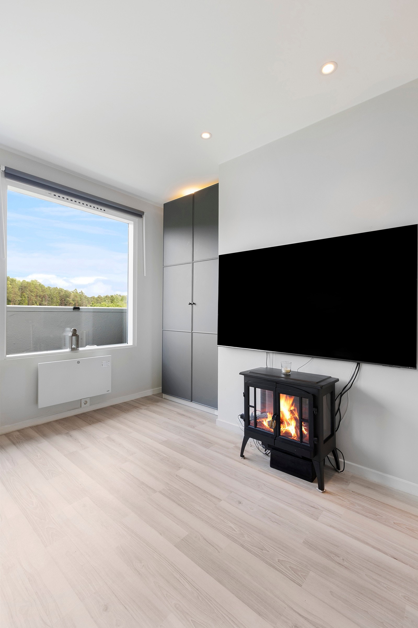 Romslig stue med lyst gulv med gulvvarme og downlights i tak Galleribilde
