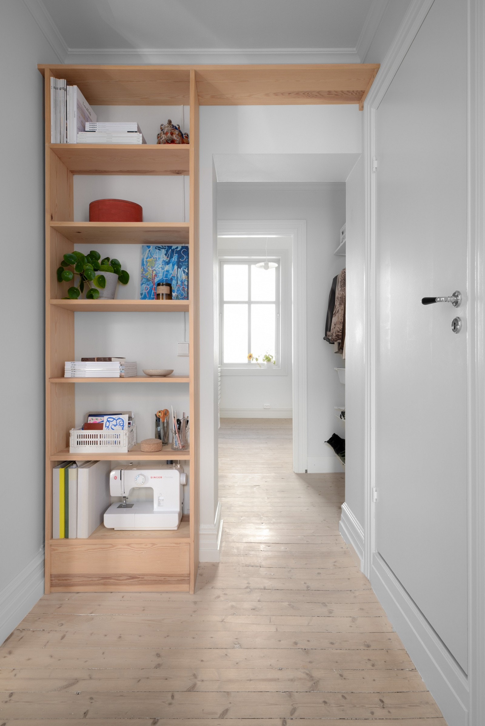 Mellomentré med plassbygde hyller og gjennomgående lys fra flere retninger. Galleribilde