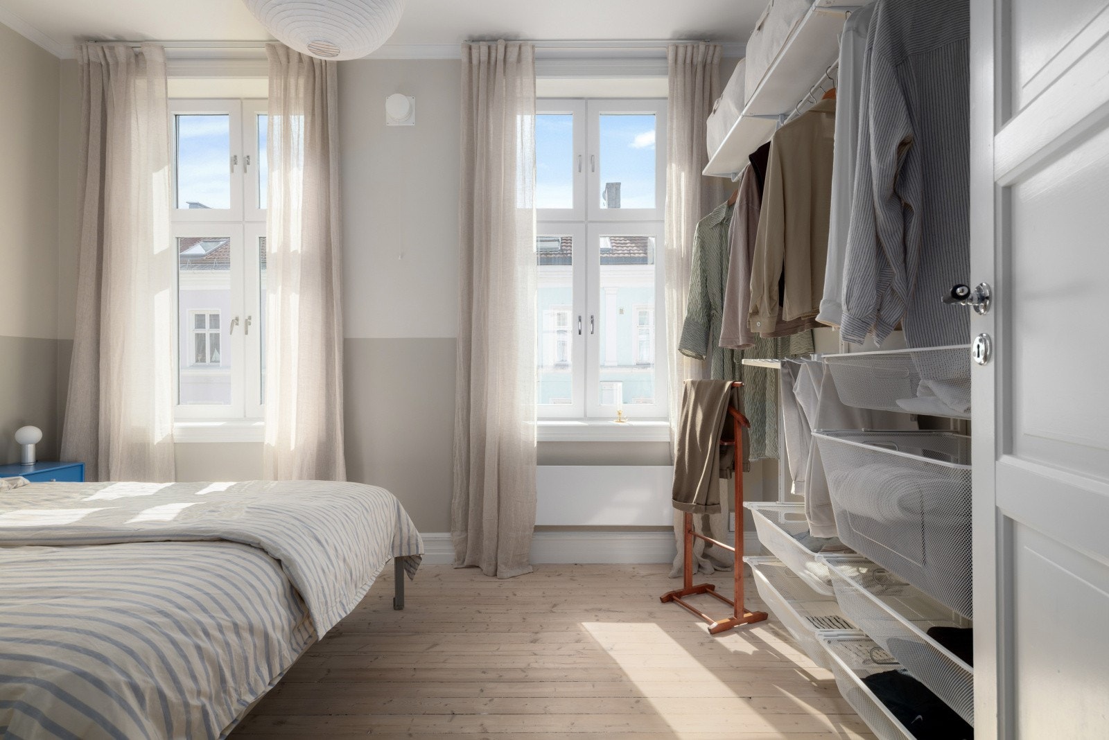 Enkel og effektiv garderobeløsning i et soverom fylt med lys og luft. Galleribilde