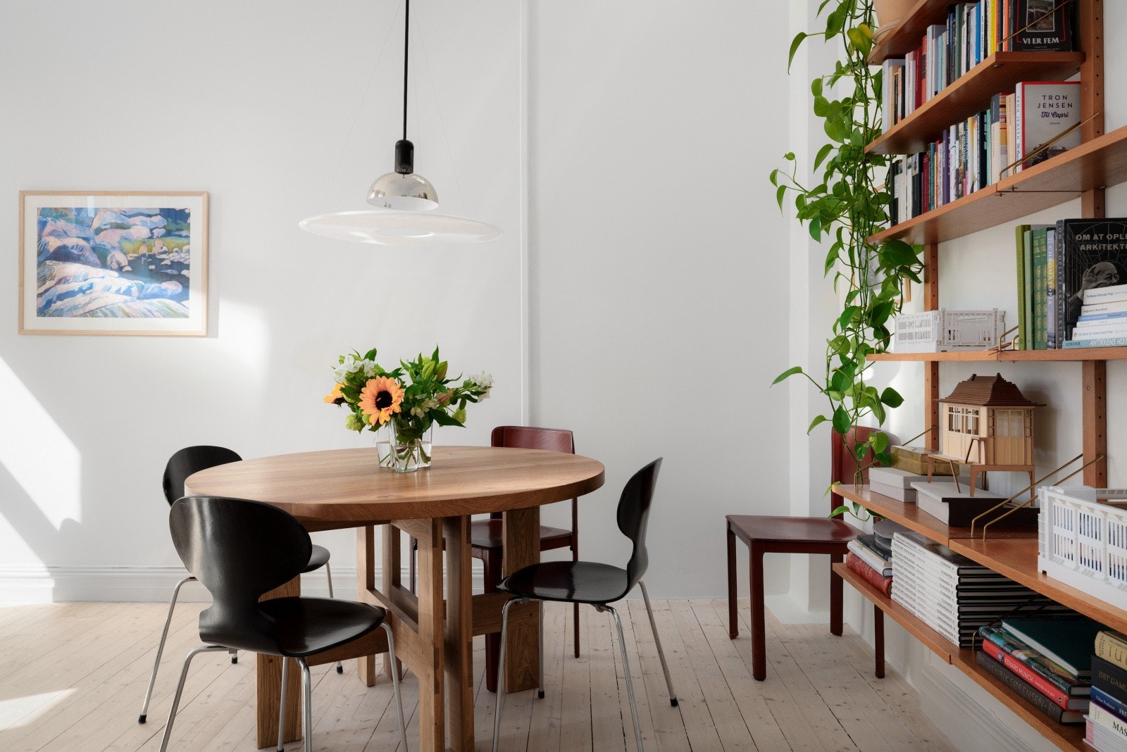 Stilren spiseplass med deilig lysinnslipp og plass til både middager og arbeid. Den åpne bokveggen gir rommet personlighet og varme. Klassisk base med urbant preg. Galleribilde