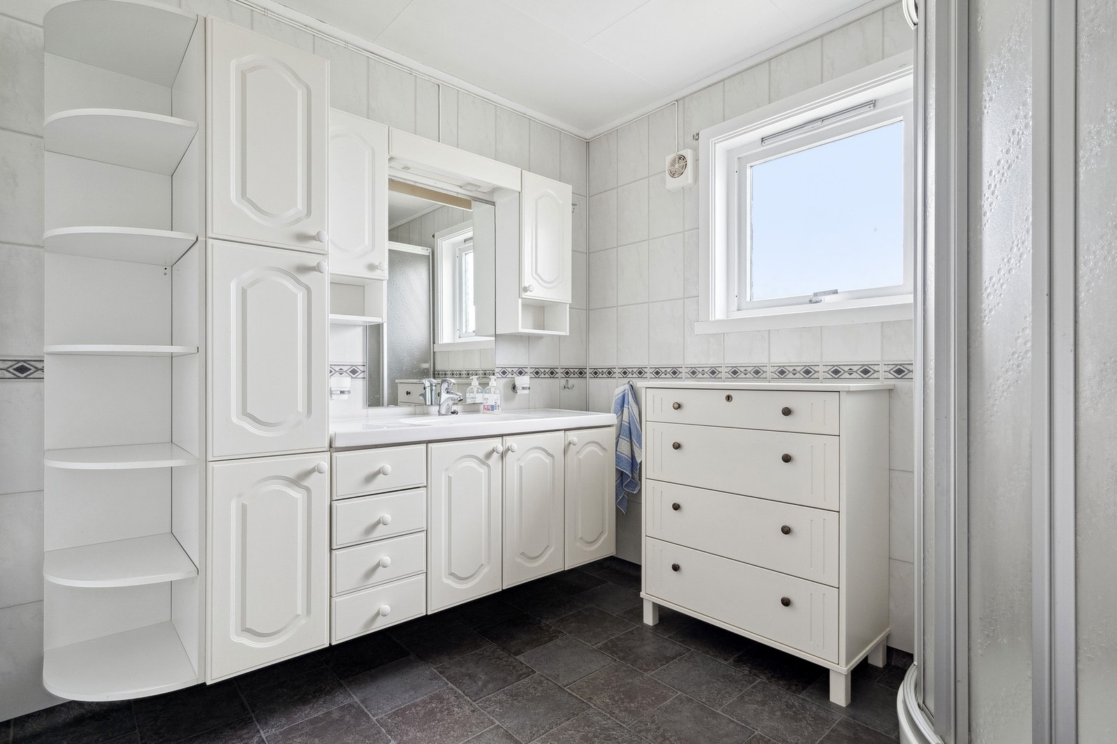 Badet har belegg på gulvet og våtromsplater på vegger. Galleribilde