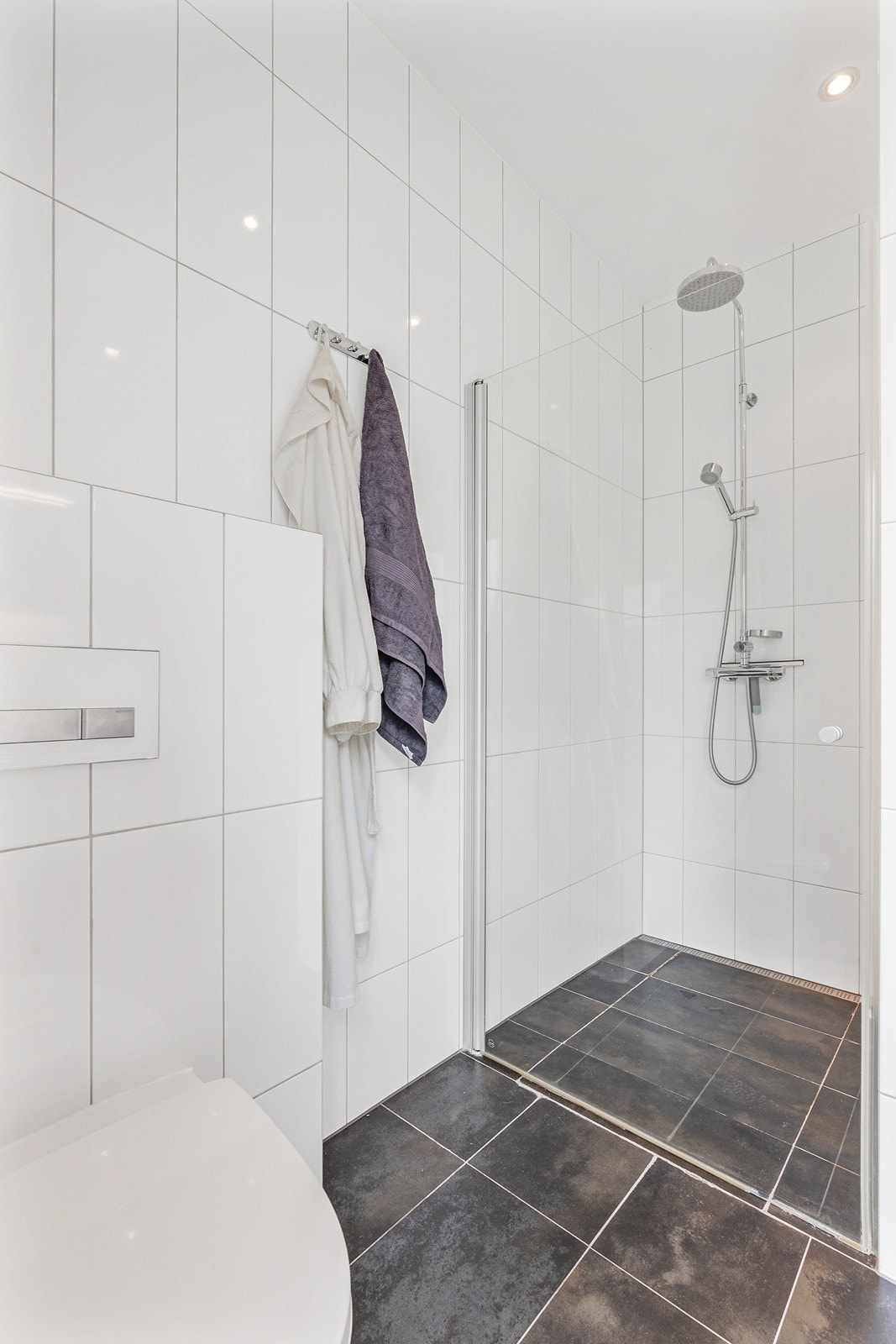 Badet er innredet med alt du trenger som innredning, dusjsone med glassdører og vegghengt wc. Galleribilde