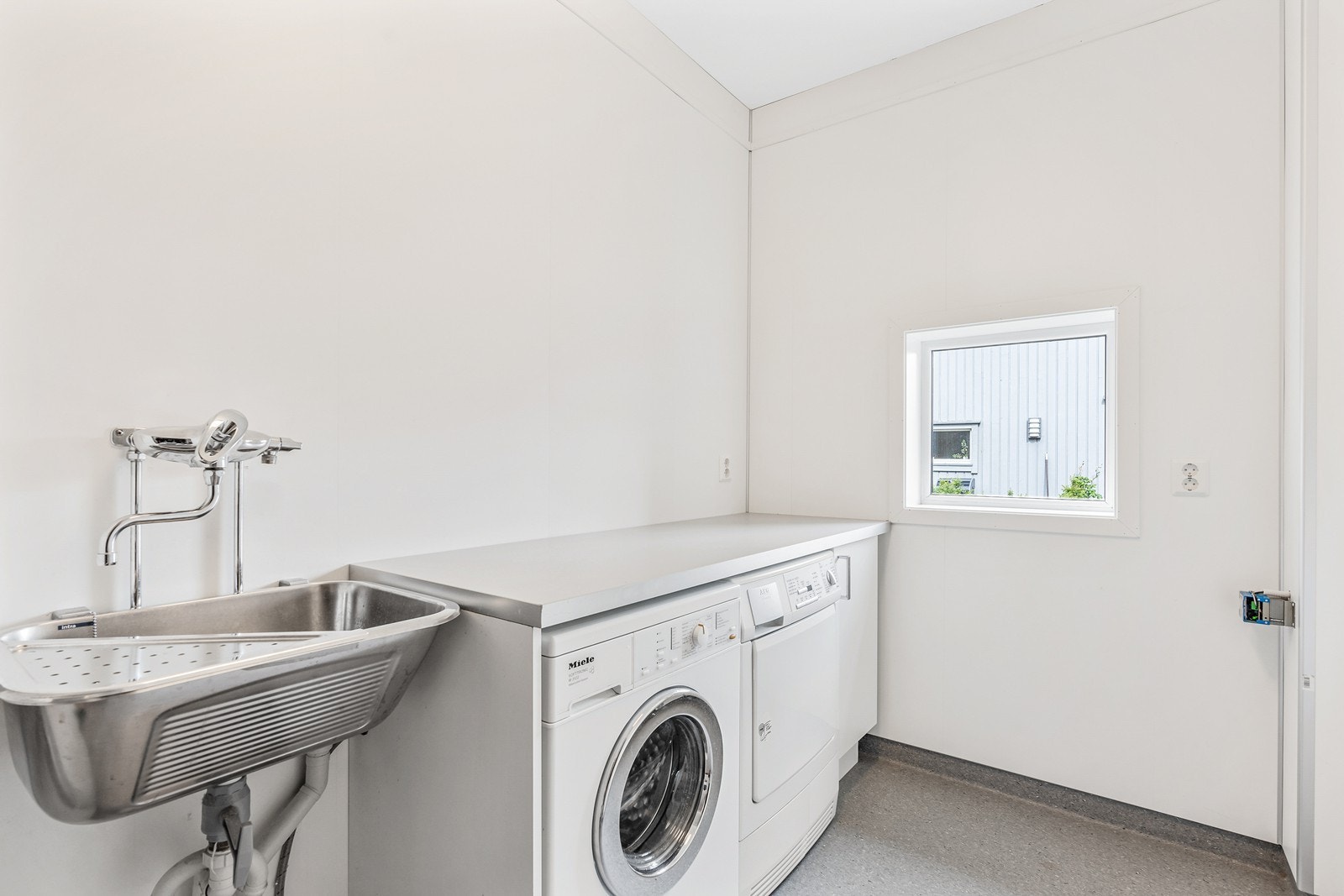 Vaskerommet er av god størrelse og pent innredet med laminatgulv, utslagsvask i tillegg til opplegg til vaskemaskin og tørketrommel. Galleribilde