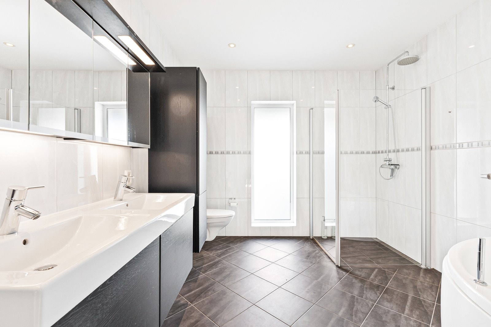 Romslig bad i 2.etasje innredet med alt du trenger som innredning, dusjsone med glassdører og vegghengt wc. Galleribilde