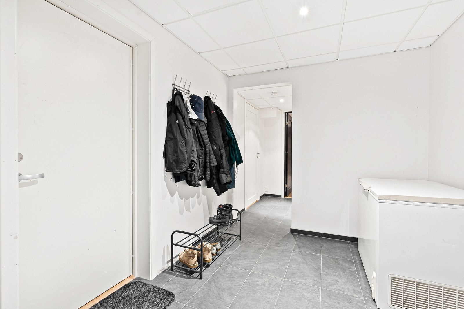 Inngangsparti i kjelleretasje, med plass til oppbevaring av sko og yttertøy og annen ønsket innredning. Galleribilde