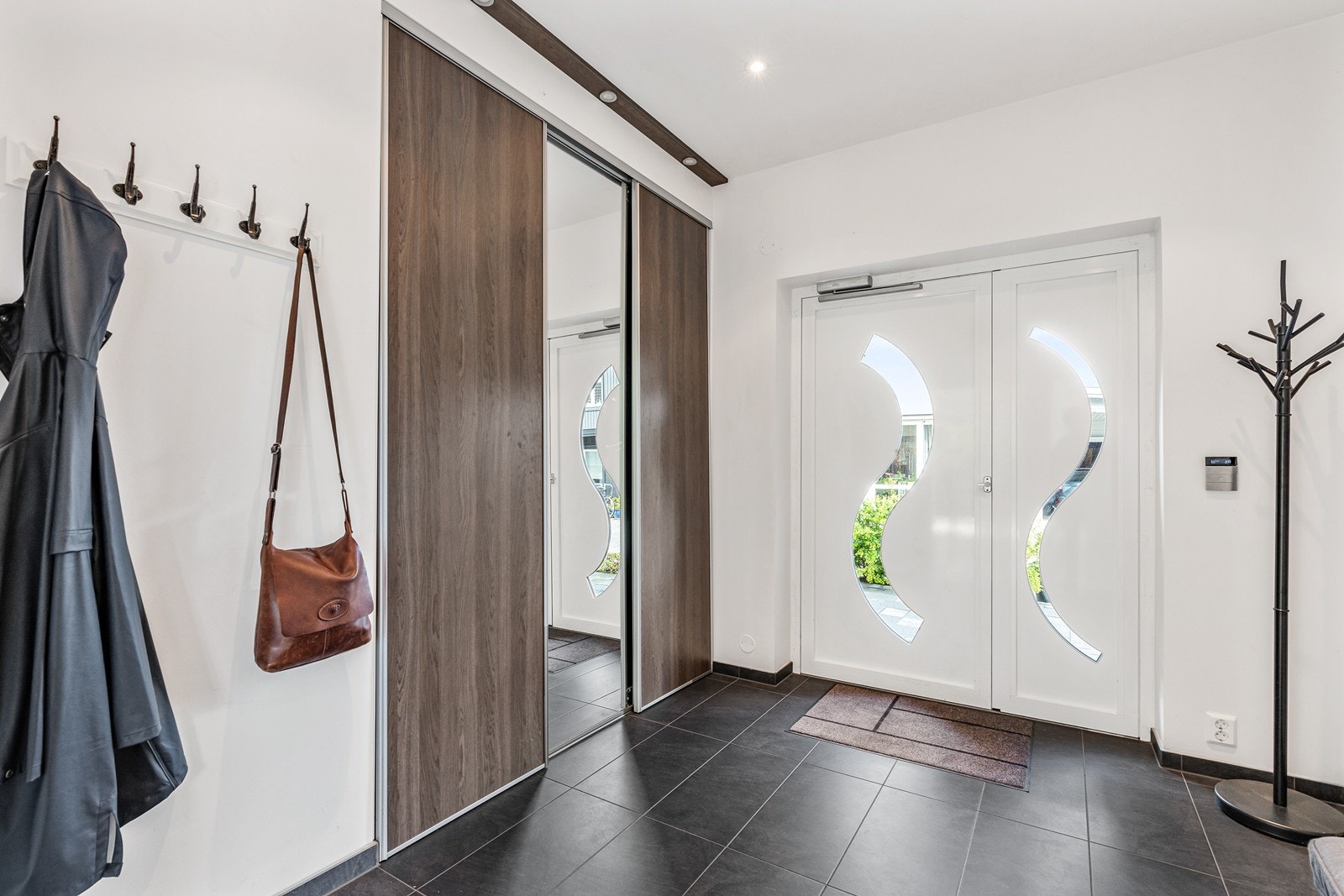 Her kan man enkelt kan henge fra seg yttertøy i en romslig garderobeløsning med speilfront. Galleribilde