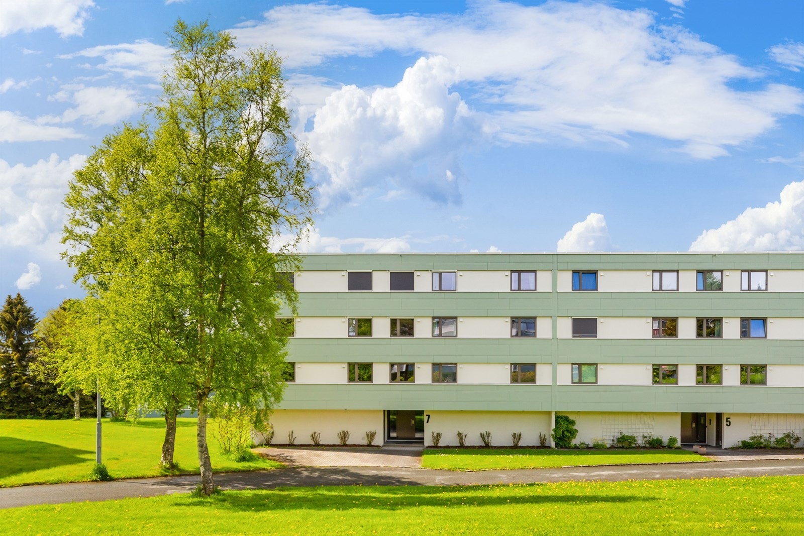 Det er flotte grøntområder rundt boligblokka. Galleribilde