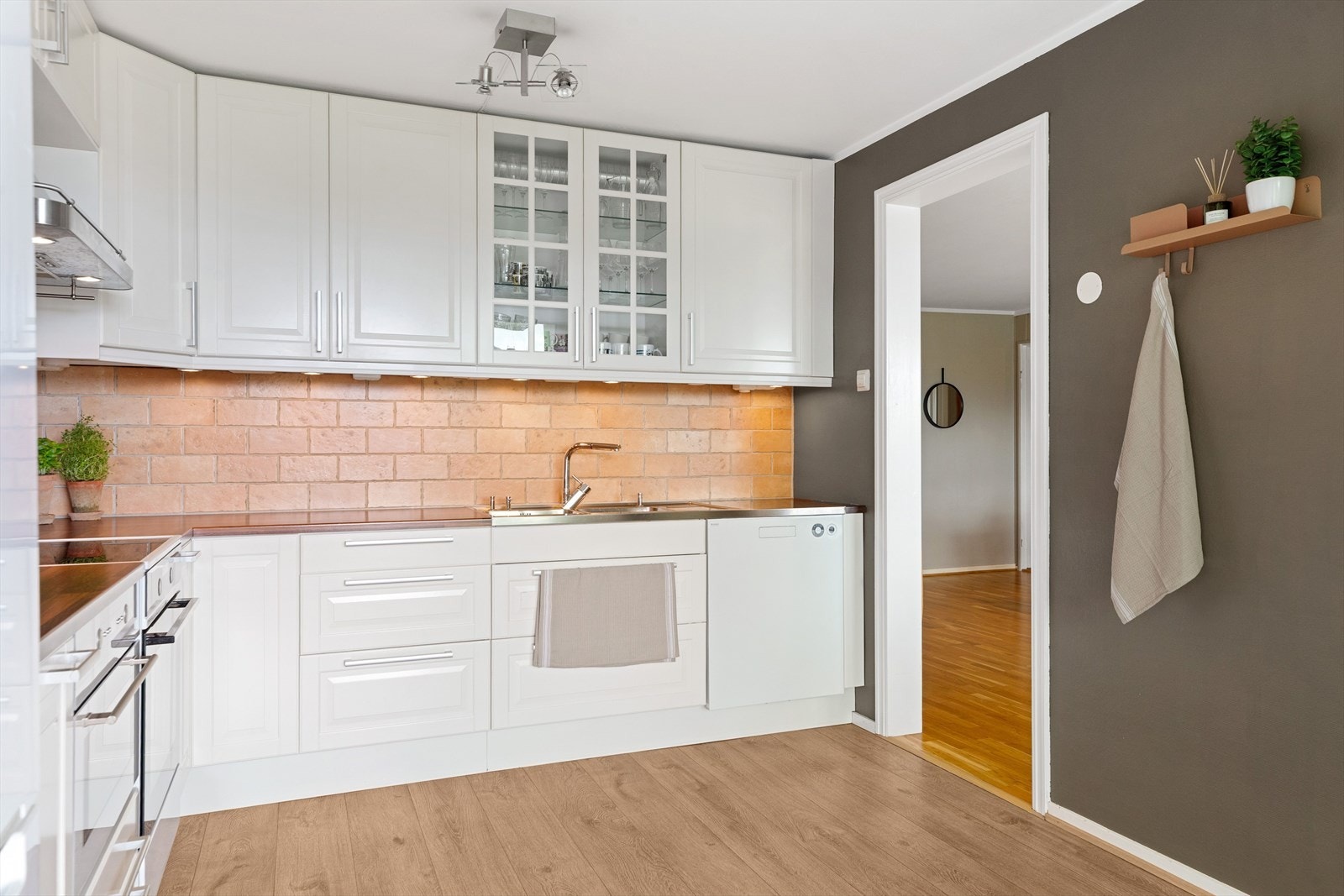 Kjøkkenet har en tidløs innredning, rikelig med benkeplass og en lun fargepalett. Galleribilde