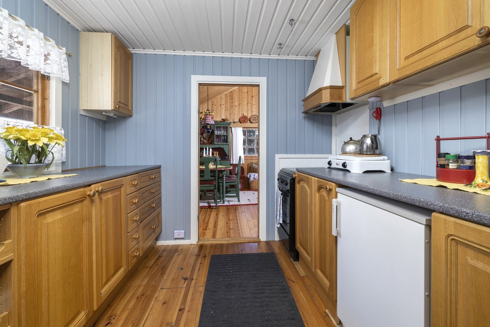 Nyere kjøkkeninnredning med profilerte fronter, laminat benkeplate og frittstående hvitevarer. Galleribilde