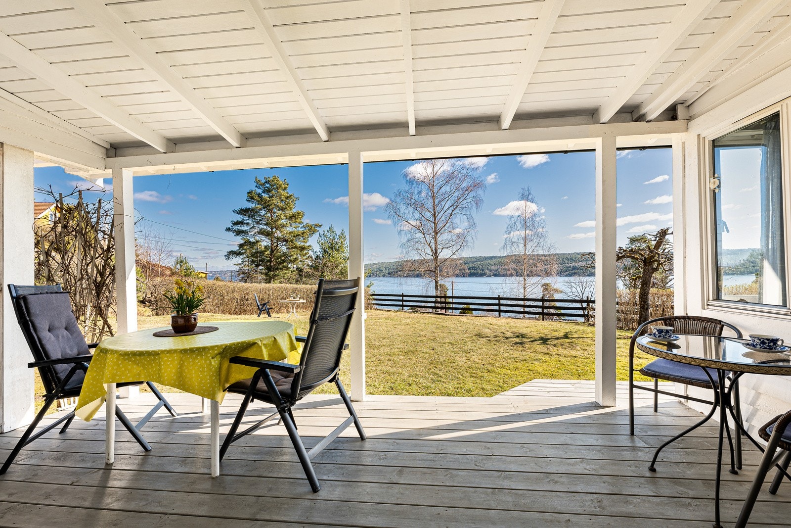 Fra terrassen nyter du en vidstrakt utsikt mot fjorden, i et fredelig uterom som inviterer til ro og nærvær. Galleribilde