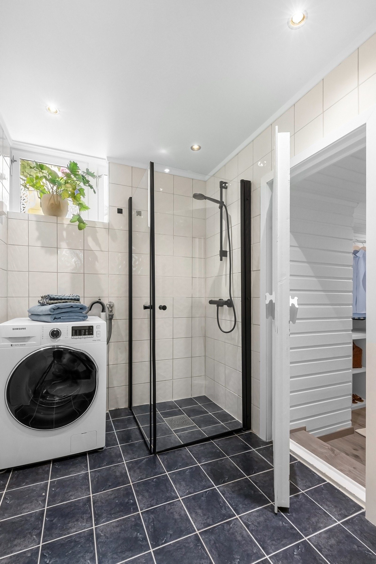 Badet har opplegg for vaskemaskin, og hyggelig lysinnslipp fra vindu Galleribilde