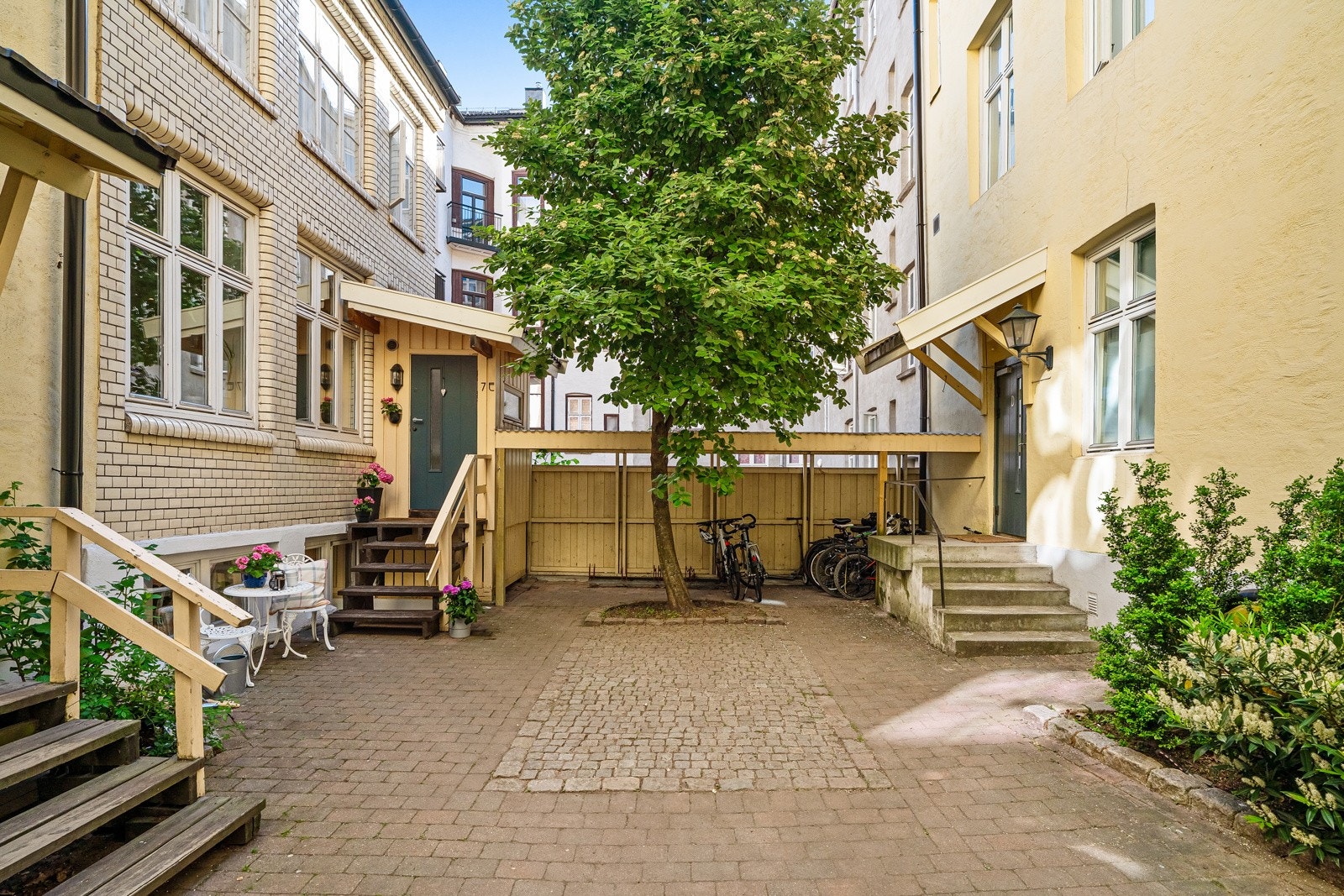 Leiligheten disponerer pent opparbeidet og skjermede bakgård med sykkelparkering, sittegrupper og beplantning Galleribilde