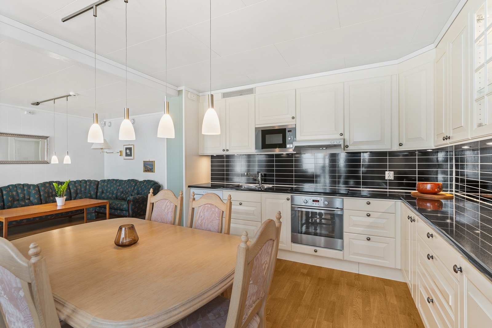 Et godt utstyrt kjøkken med hvitevarer bestående av kjøleskap, oppvaskmaskin, stekeovn, koketopp og mikroovn. Galleribilde