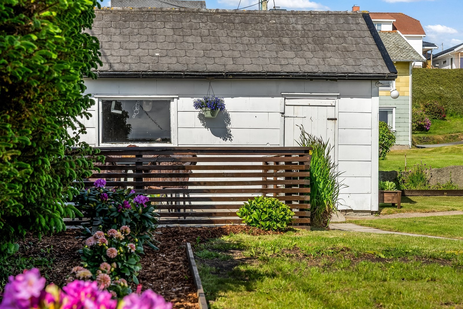 Tomta er pent opparbeidet med barklagte bed, gresslagte områder og fine uteplasser. Galleribilde