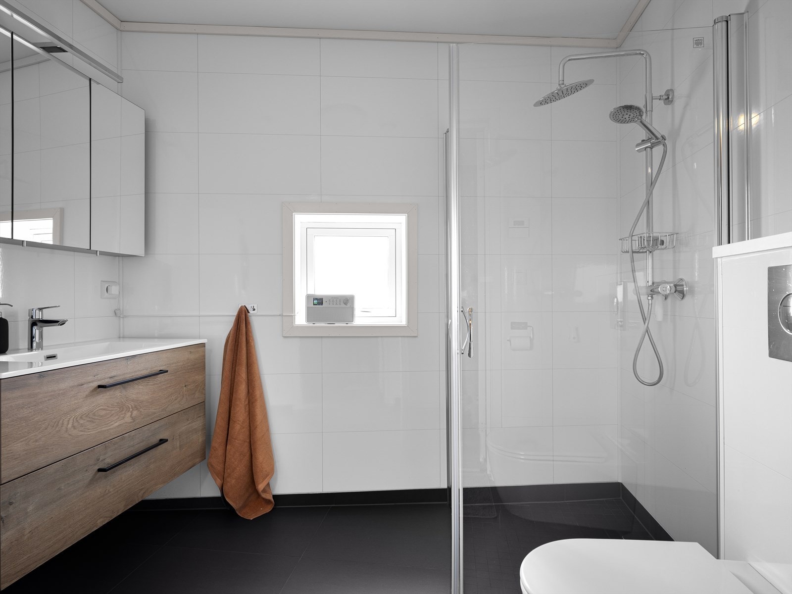 Badet er utstyrt med morderne baderomsinnredning, dusjhjørne og vegghengt toalett. Galleribilde