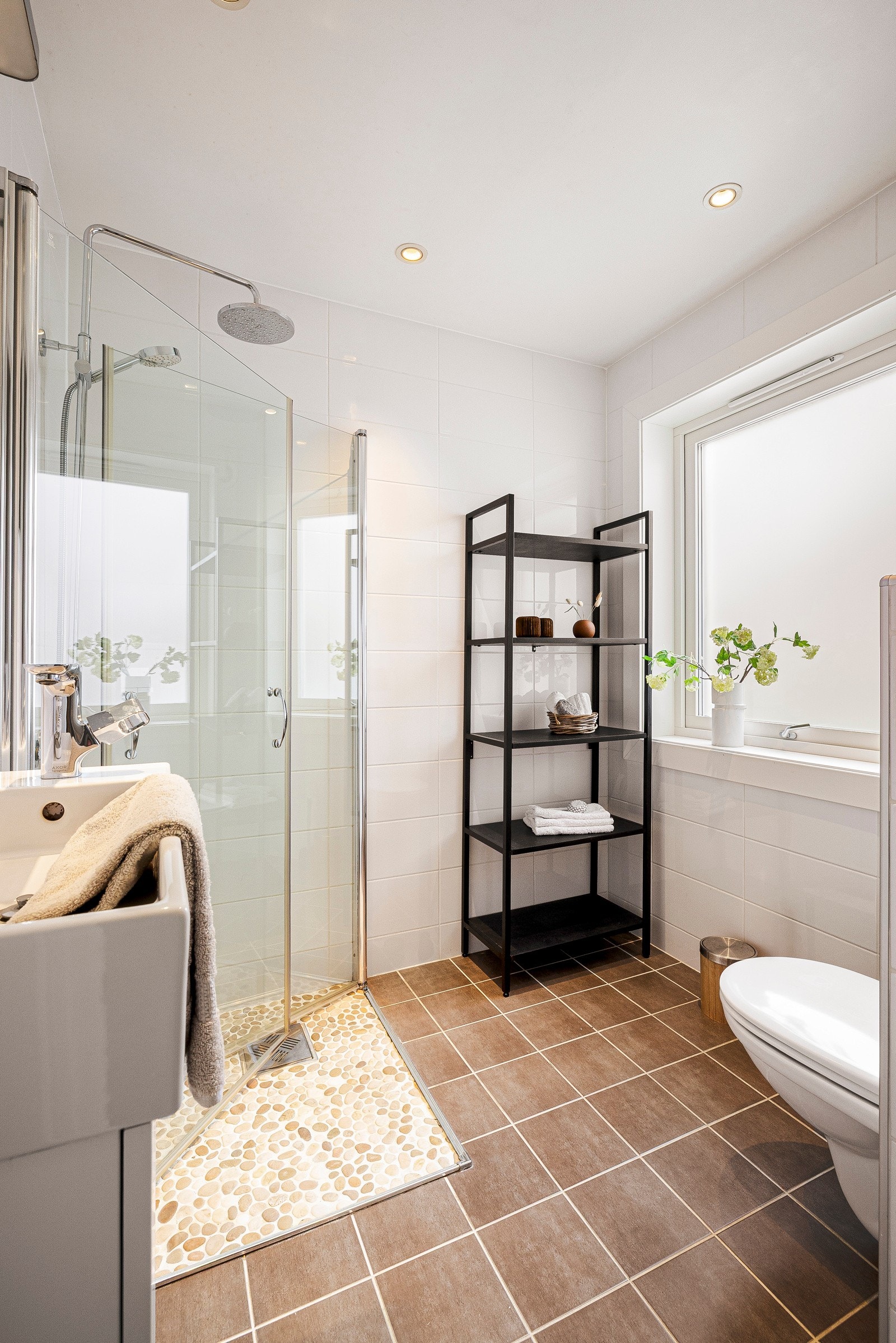 Badet inneholder vegghengt toalett, dusj, servant med innredning, varmekabler i gulv og avtrekksventil i yttervegg. Galleribilde