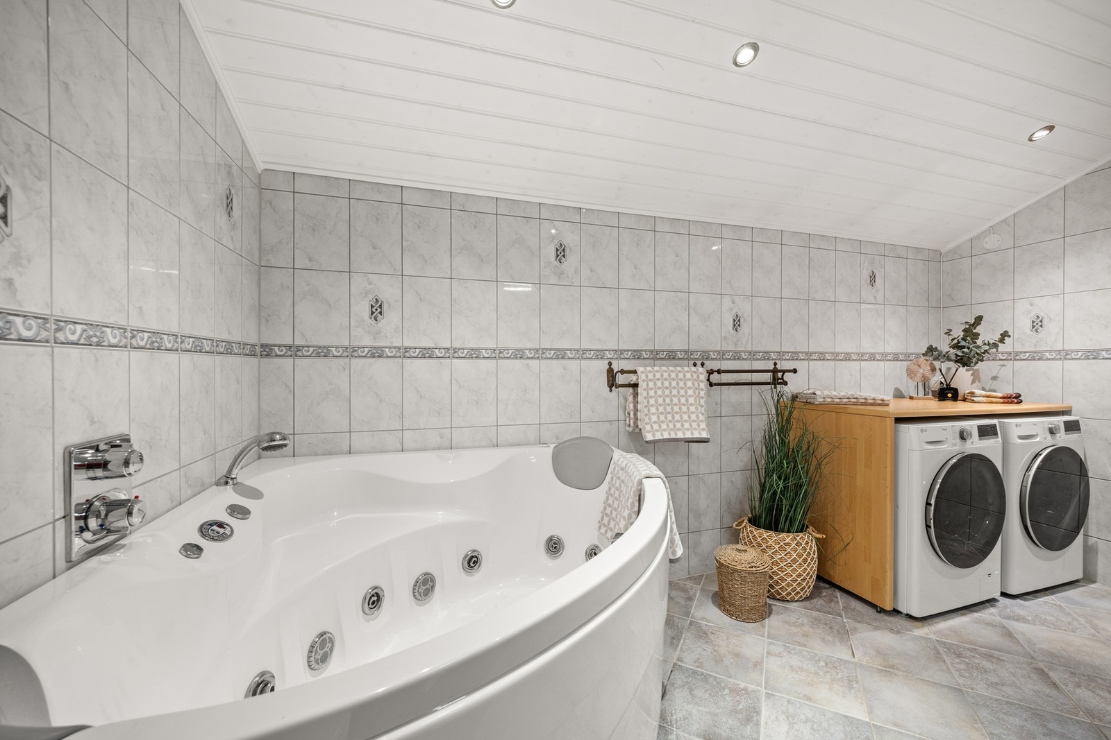 Badet har innbygget badekararmatur, vegghengt toalett og opplegg for både vaskemaskin og tørketrommel Galleribilde