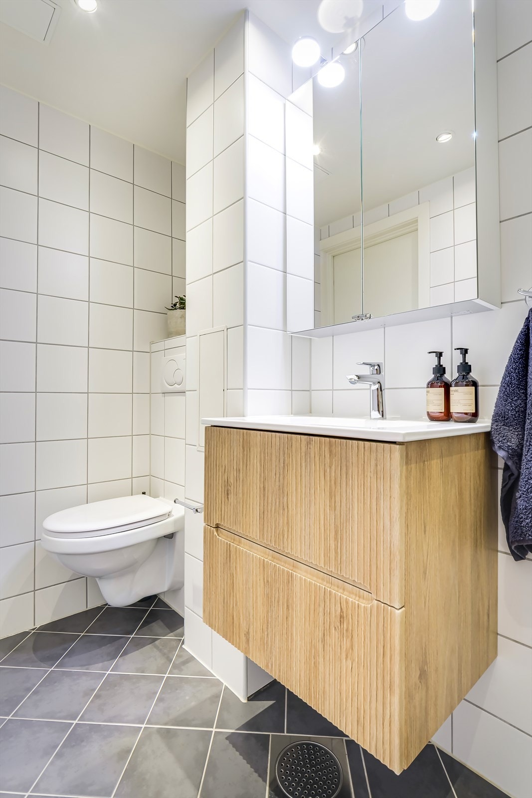 Innredningen består av heldekkende servant med innredning, speilskap, vegghengt toalett og dusjhjørne med svingbare glassdører. Opplegg for vaskemaskin Galleribilde