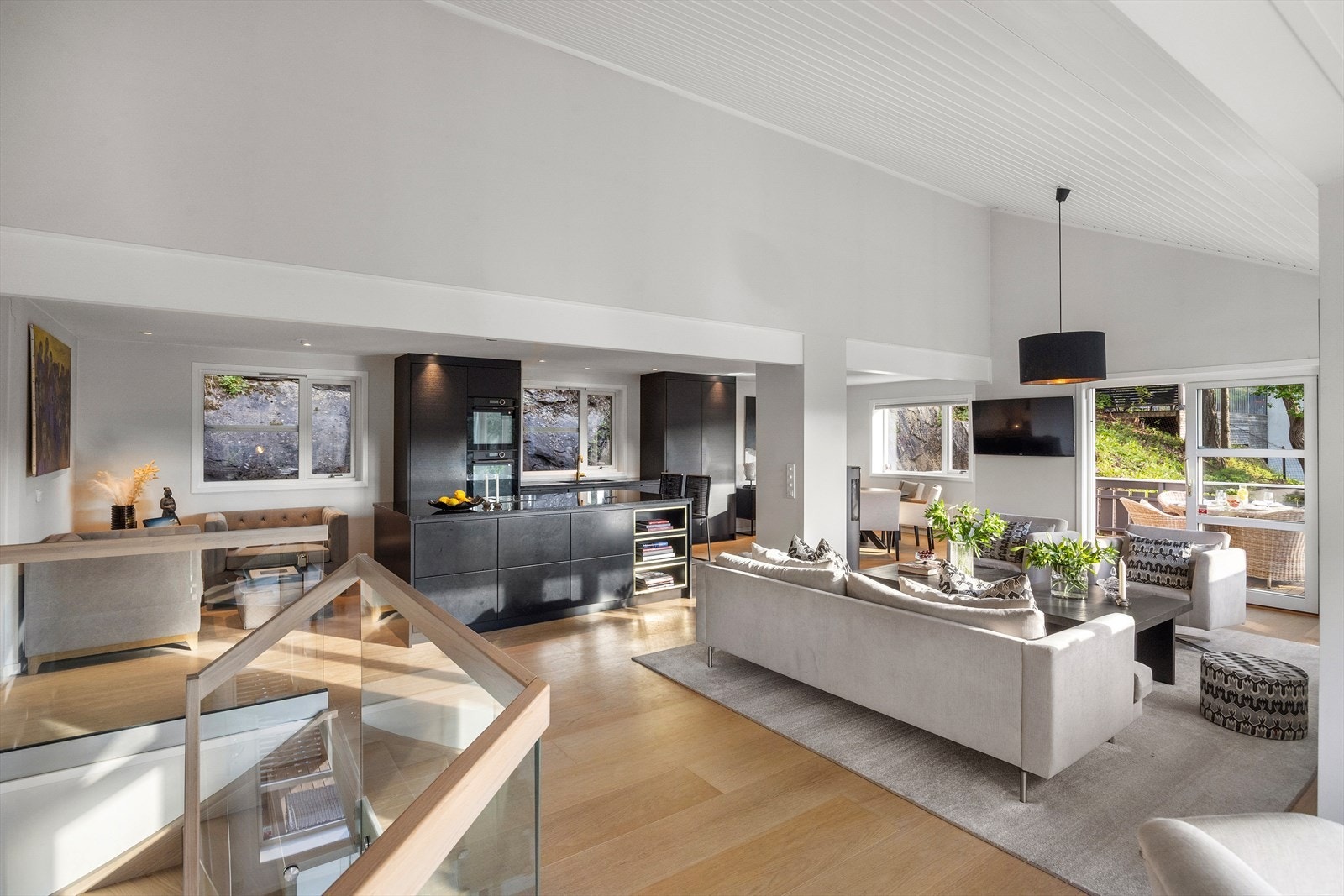 Det åpne kjøkkenet mot stuen inviterer til sosialt samvær og gir rommet en luftig og inkluderende følelse. Galleribilde