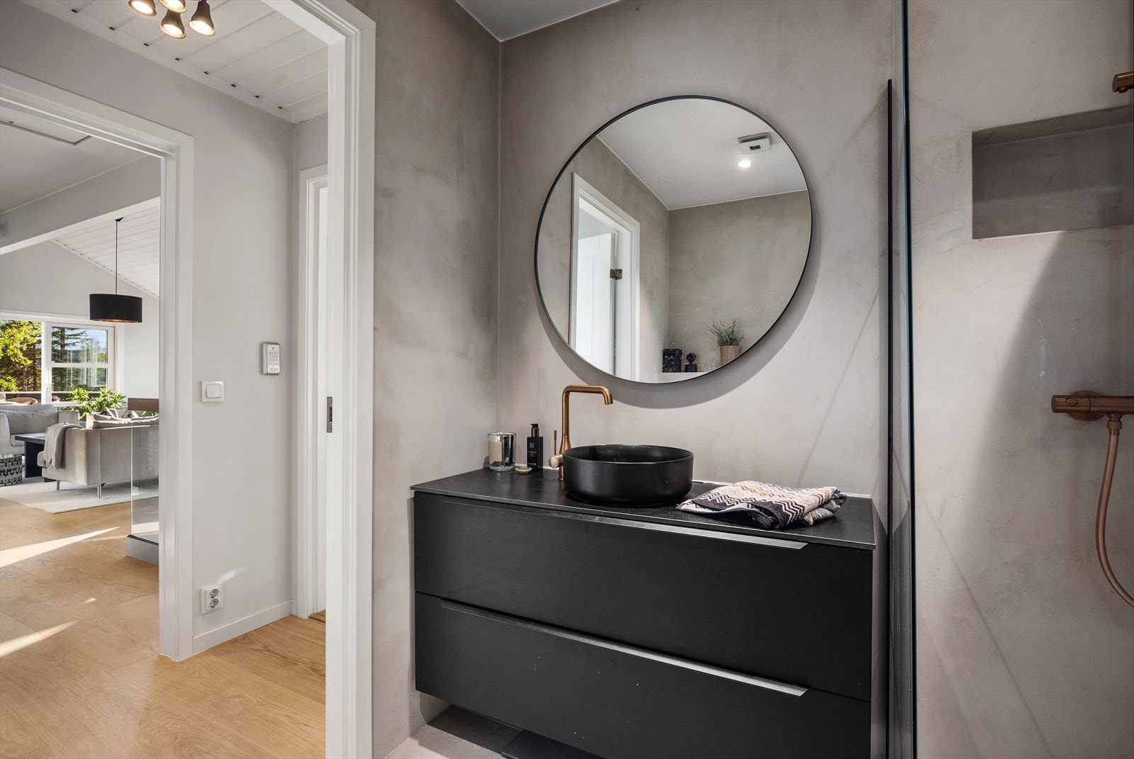 Downlights i taket gir godt lys, og badet er innredet med vegghengt toalett, servant på innredning og speil. Galleribilde