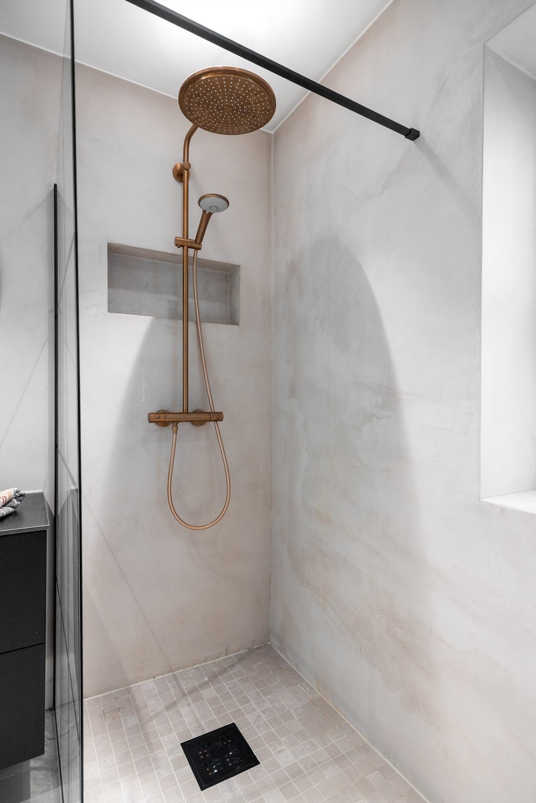 Badet har en stilren dusjnisje med glassvegg og moderne regnfallsdusj for en luksuriøs opplevelse. Galleribilde