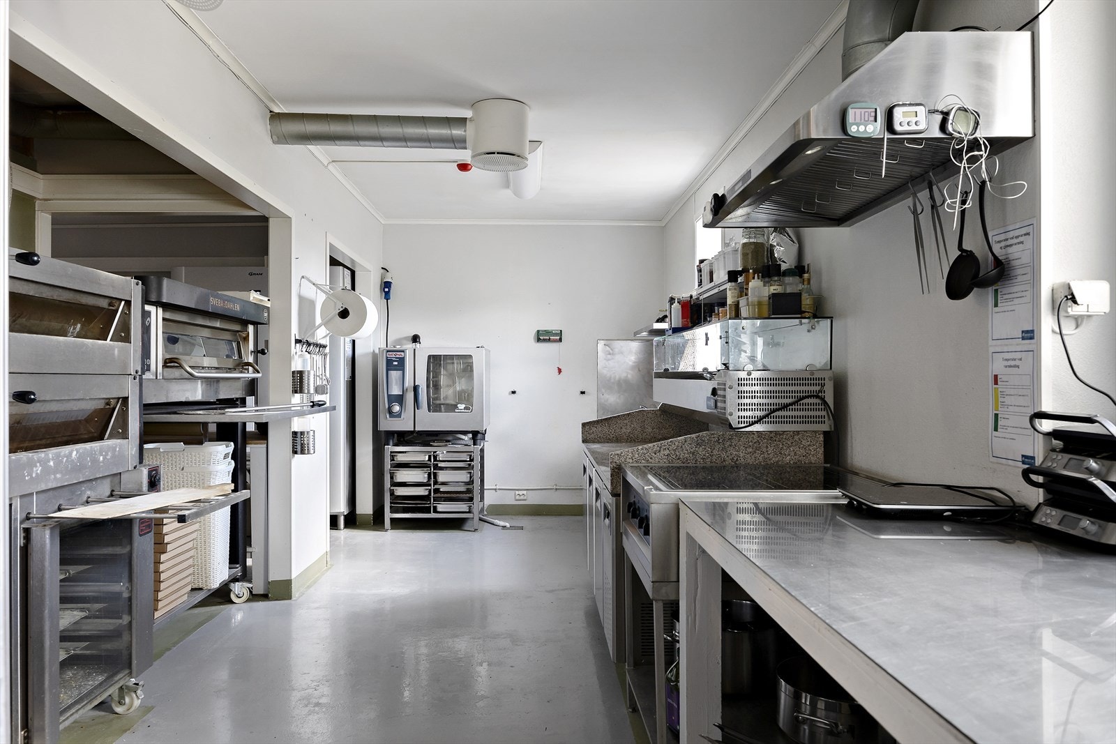 Romslig, funksjonelt kjøkken med moderne utstyr i profesjonelle omgivelser. Galleribilde