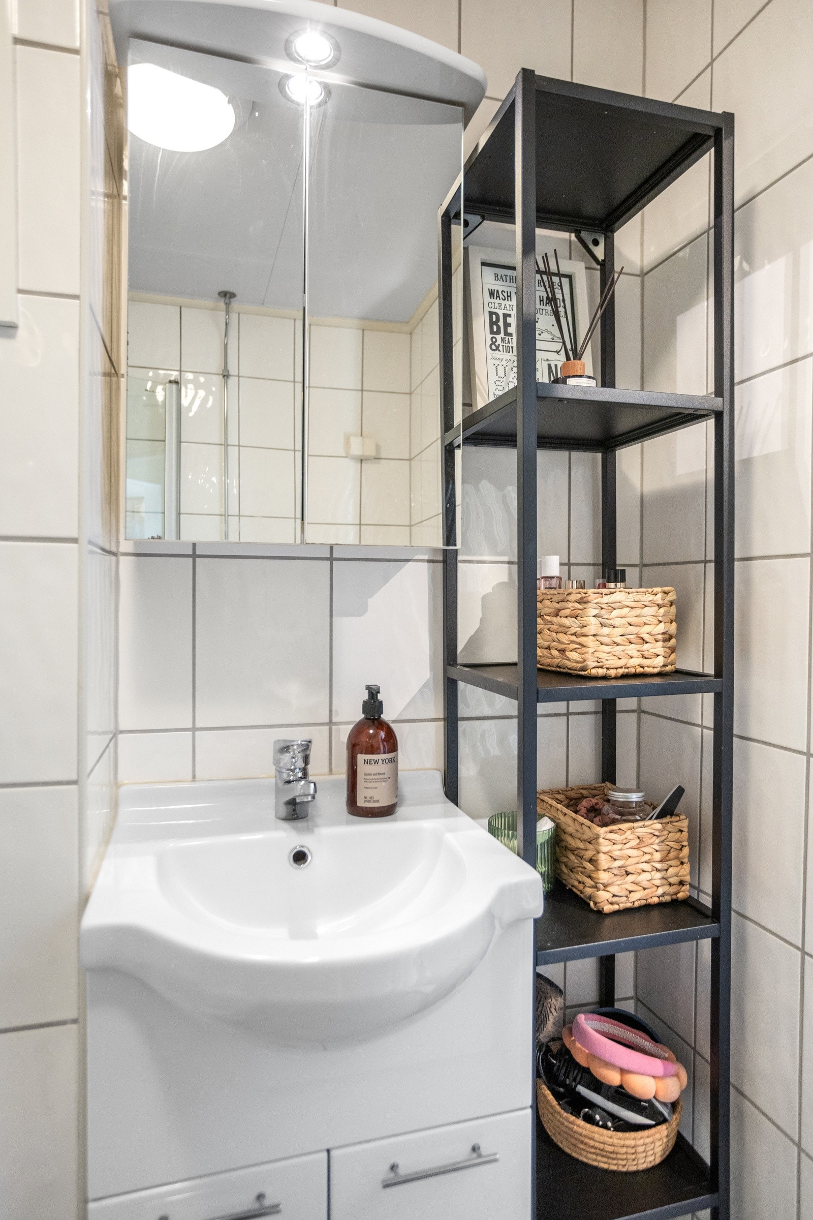 Badet er innredet med vegghengt toalett, servant, servantskap, overskap med speil, dusjhjørne, opplegg til vaskemaskin Galleribilde