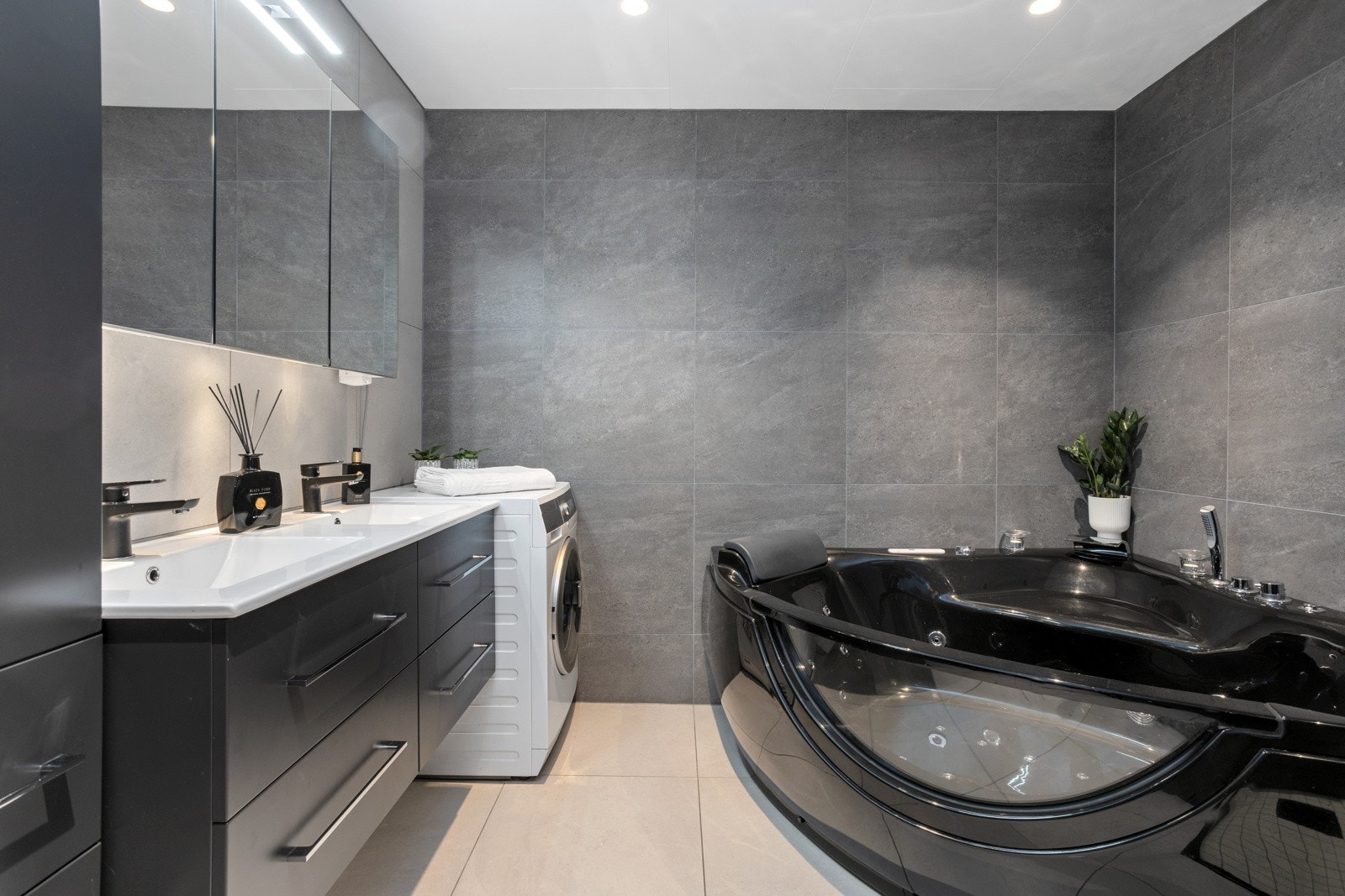 Totaloppusset bad med storformat fliser, dusjenisje og hjørneboblekar, solid innredning med dobbelvask, downlights og varmekabler i gulv | opplegg for vaskemaskin Galleribilde