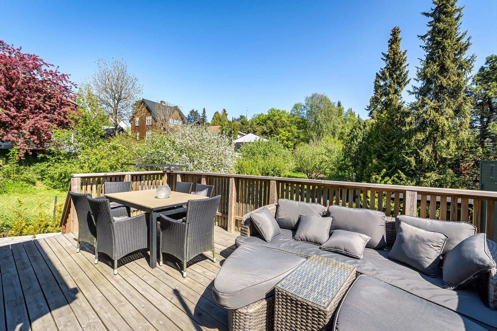 Terrassen ligger skjermet mellom husvegg. Det romslige arealet gir rikelig med plass til sofagruppe, langbord og grill. Galleribilde