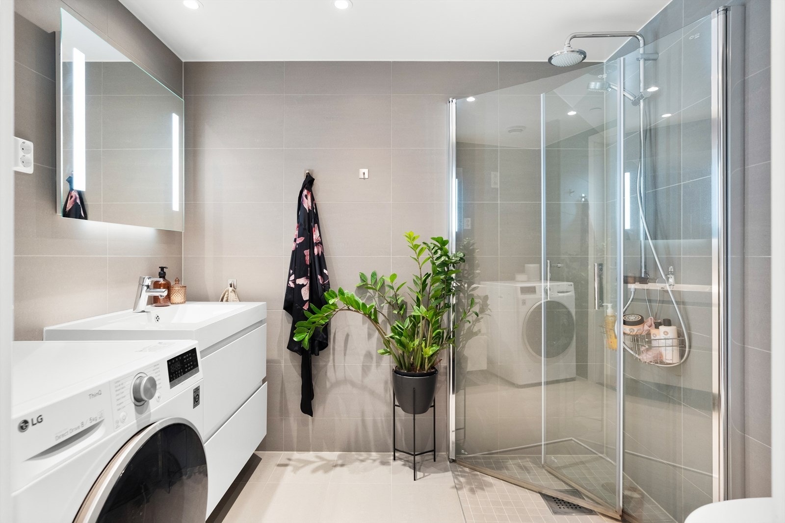 Videre har badet vegghengt toalett og dusjnisje med innfellbare glassdører. Det er opplegg for vaskemaskin og tørketrommel Galleribilde