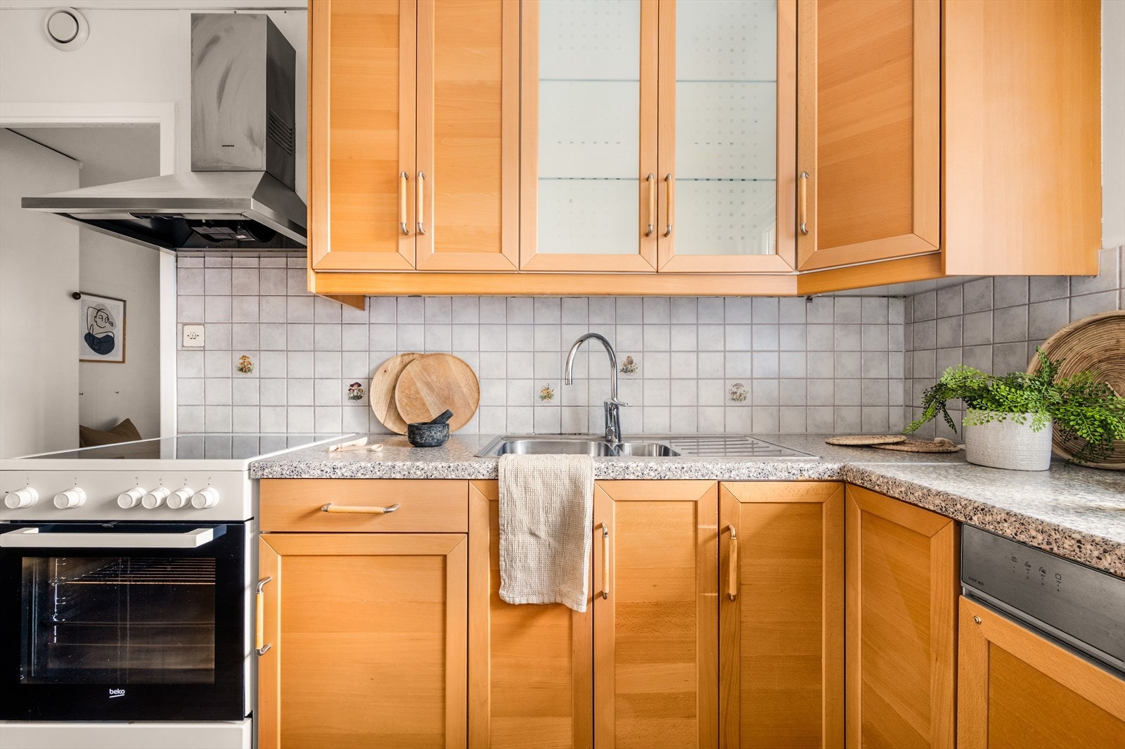 Med glassfronter på ett av overskapene og integrert oppvaskmaskin, har kjøkkenet en praktisk utforming med god oversikt og funksjonelle løsninger til daglig bruk. Galleribilde