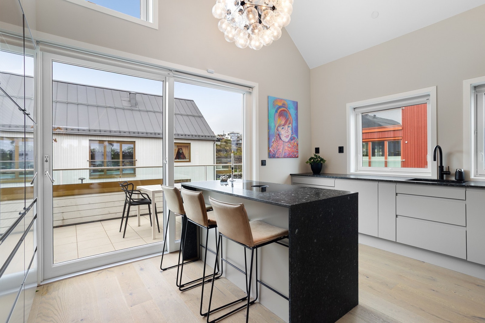 Stilig kjøkken med sitteplasser rundt kjøkkenøy gjør også dette rommet sosialt. Galleribilde