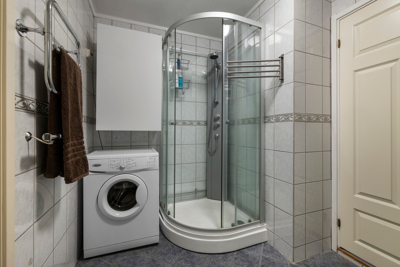 Badet er innredet med dusjkabinett og opplegg for vaskemaskin Galleribilde