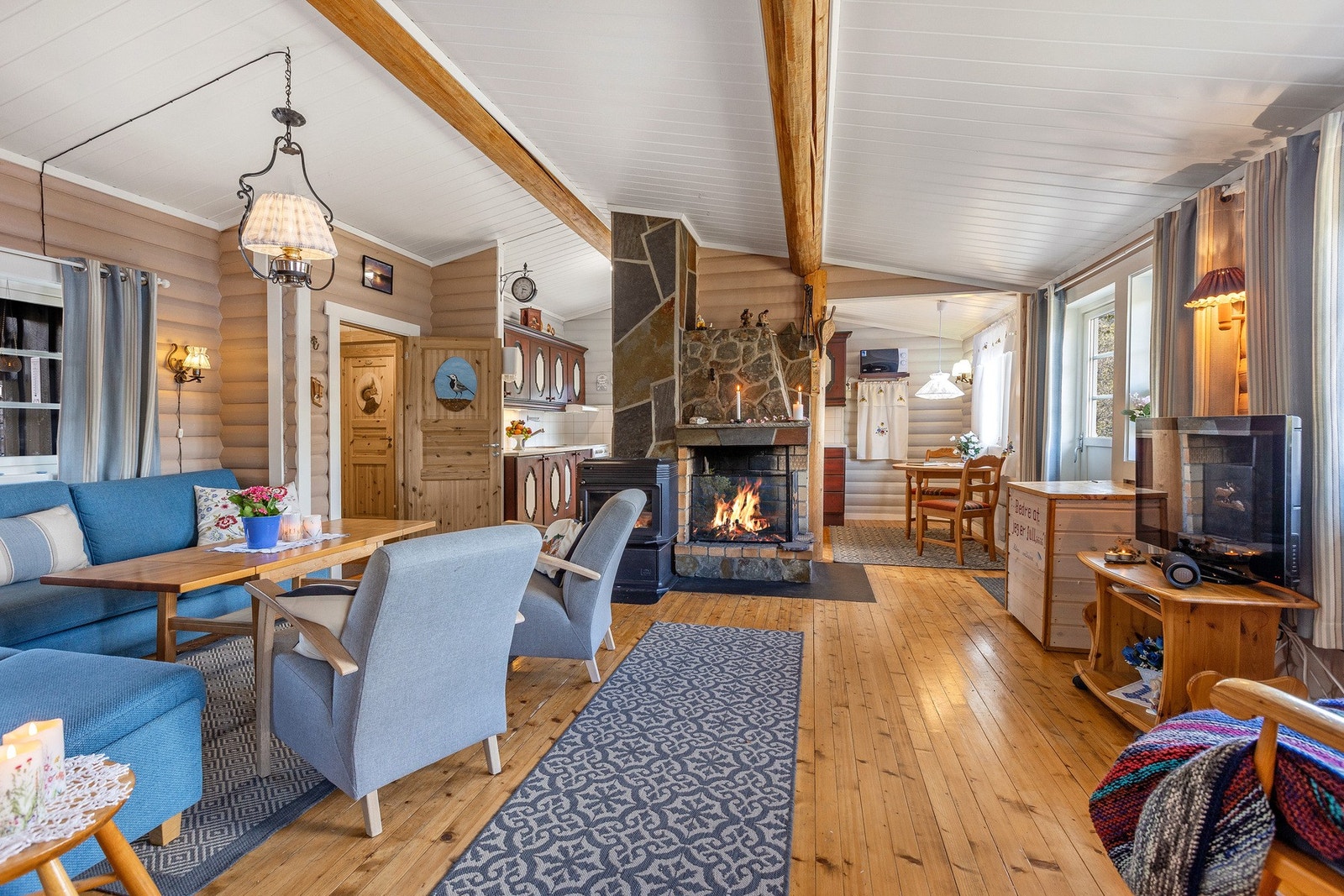 Stuen har lakkerte tregulv og panelvegger som gir et solid og praktisk utgangspunkt for innredning. Galleribilde