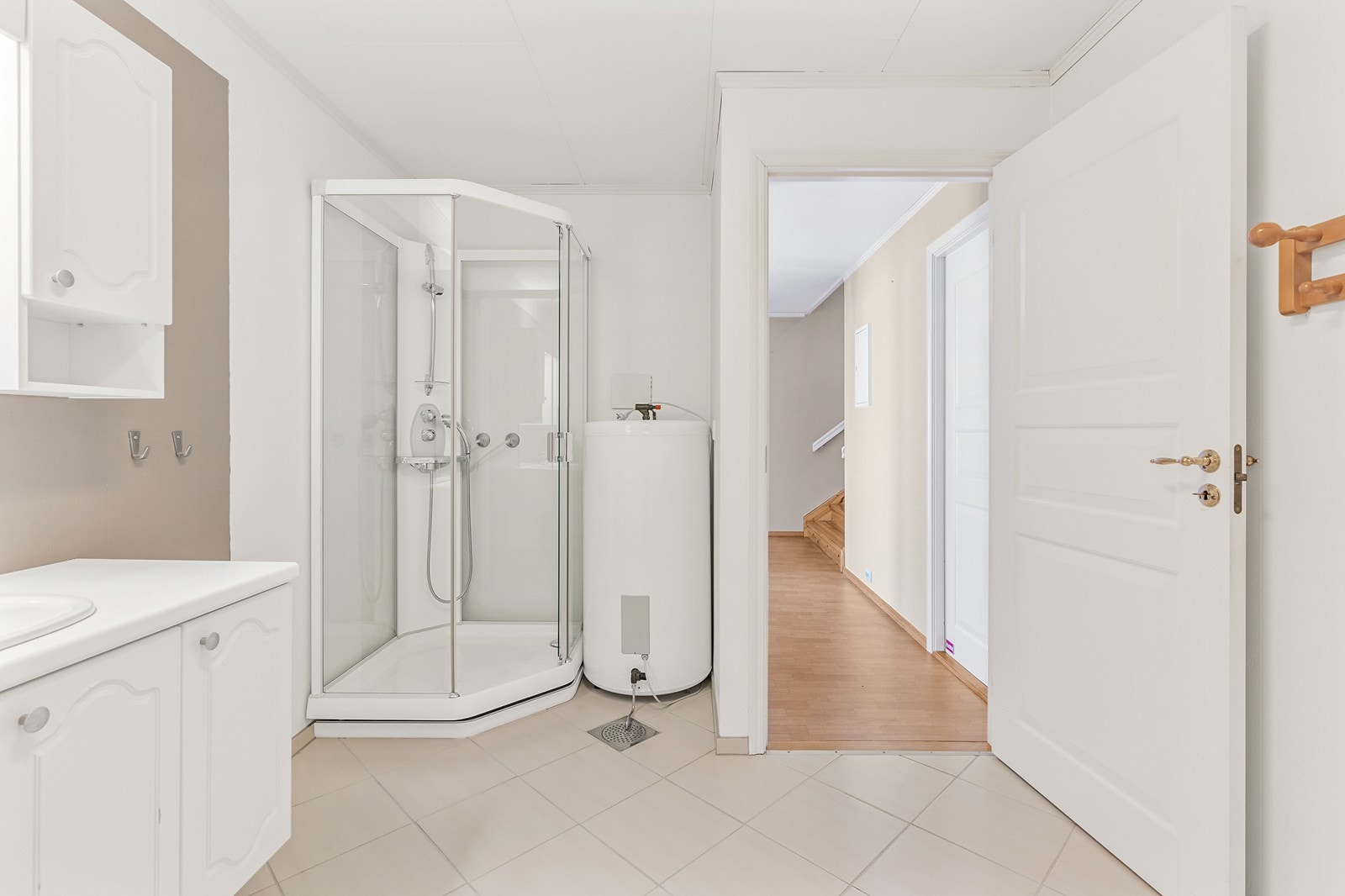 Badet har flislagt gulv, våtromstapet på vegger og er utstyrt med dusjkabinett, baderomsinnredning, toalett, brannslange og opplegg for vaskemaskin Galleribilde