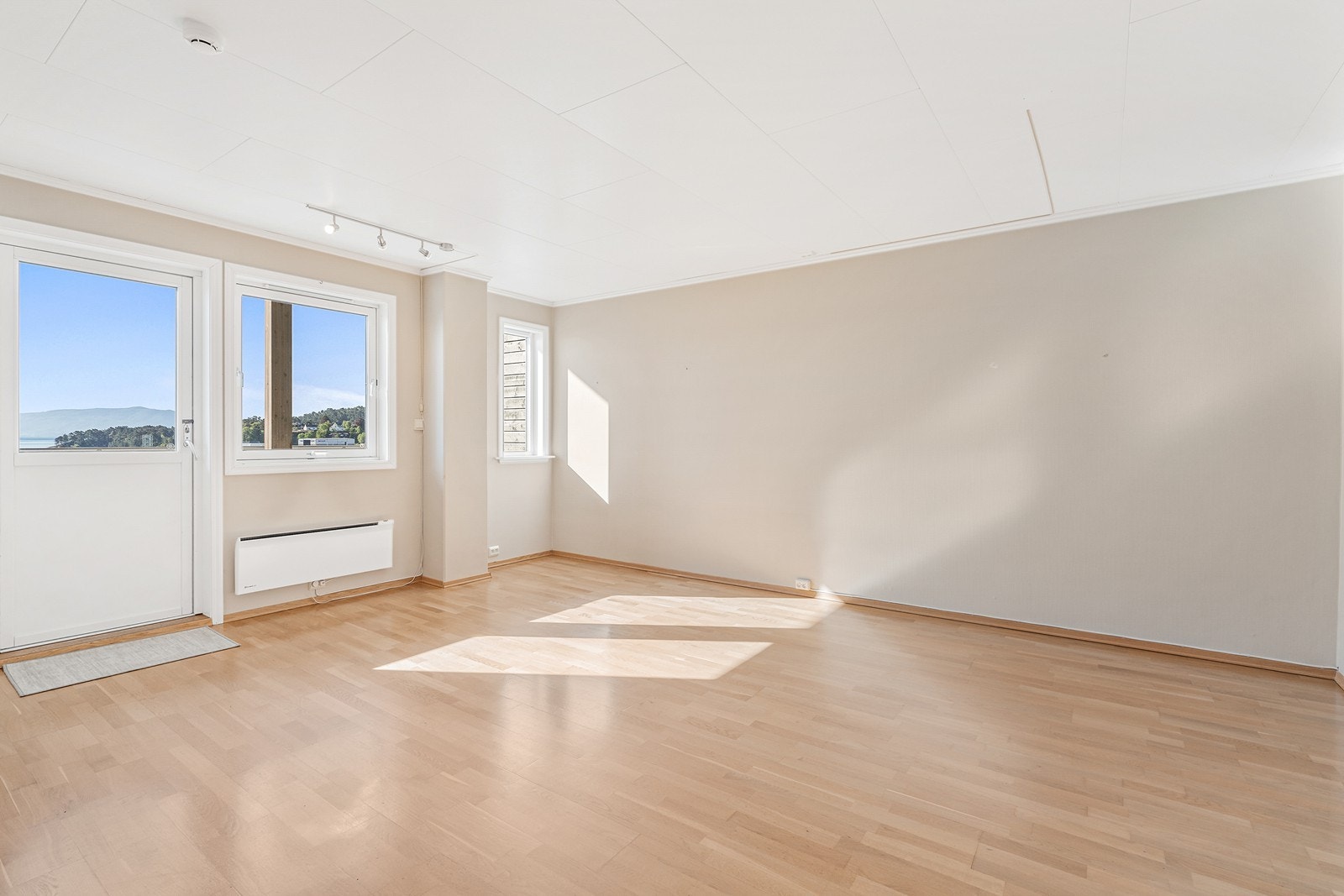 Når du trer inn i stuen, møtes du av store vindusflater og en nydelig utsikt - rett over innseilingen til Leirvik hamn Galleribilde