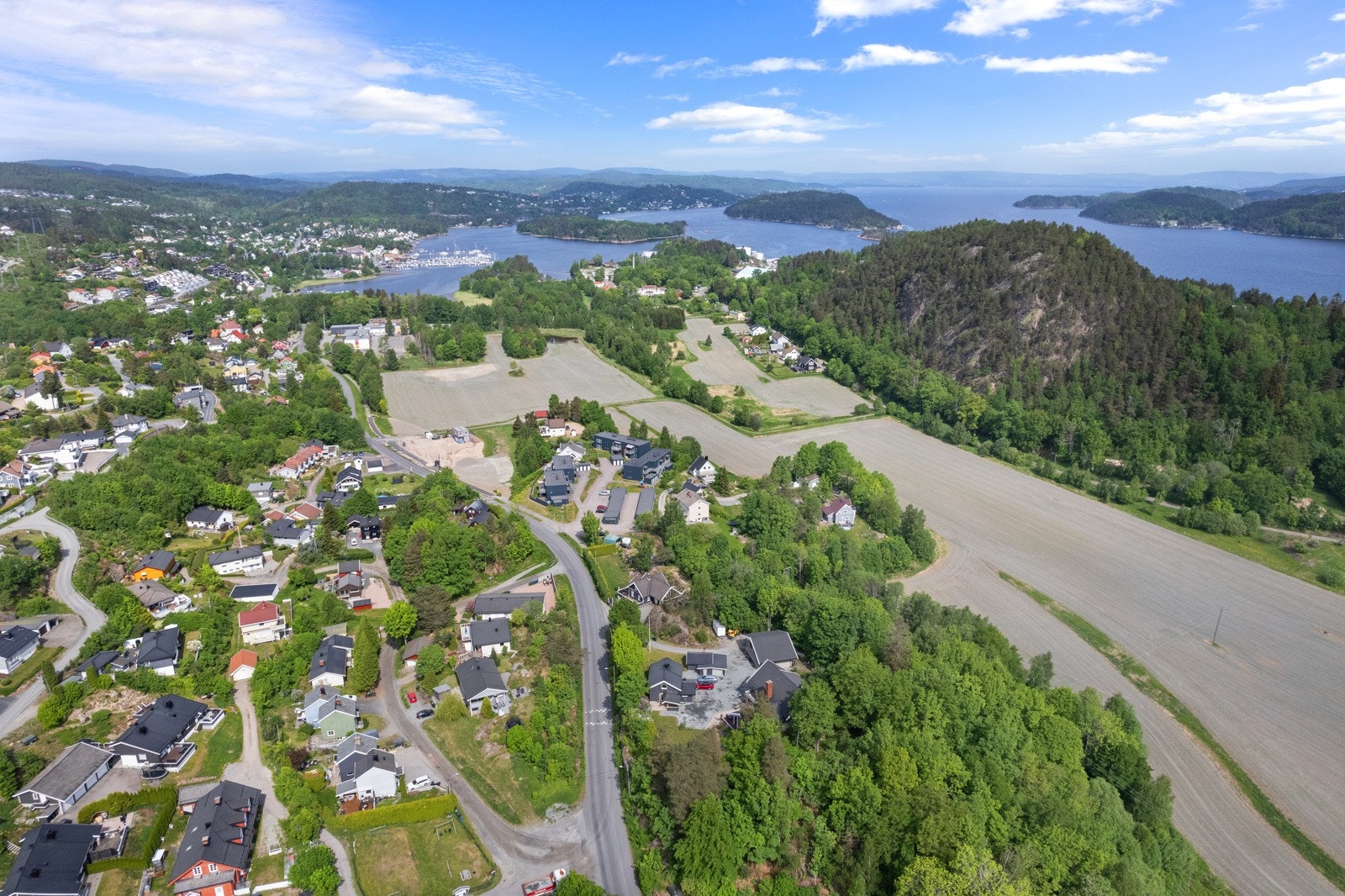 Kort avstand ned til fjorden med båthavn og flere badeplasser Galleribilde