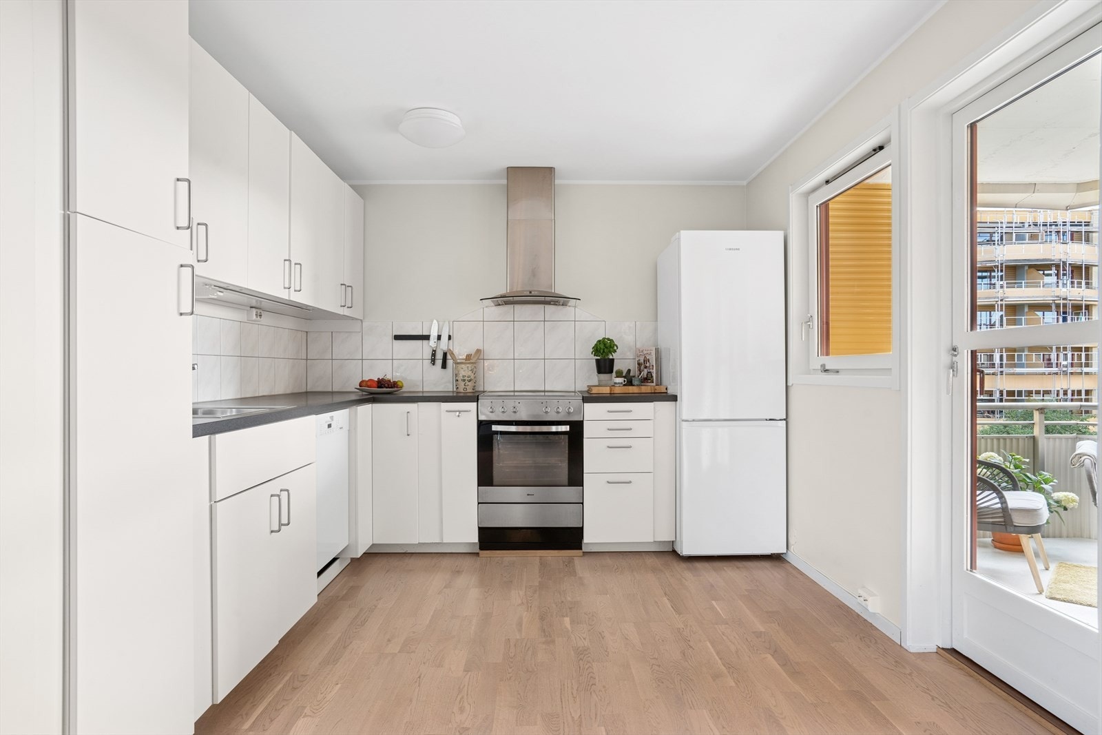 Det er utgang til balkongen fra kjøkkenet. Vindu og balkongdør gir mye naturlig lysinnslipp. Galleribilde