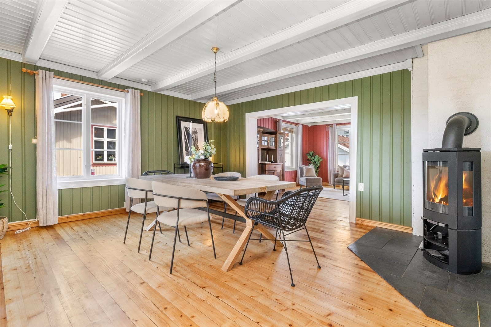 Det er tregulv på gulv og fliselagt ved peis, panel på vegg og synlige bjelkelag og panel i himling. Galleribilde