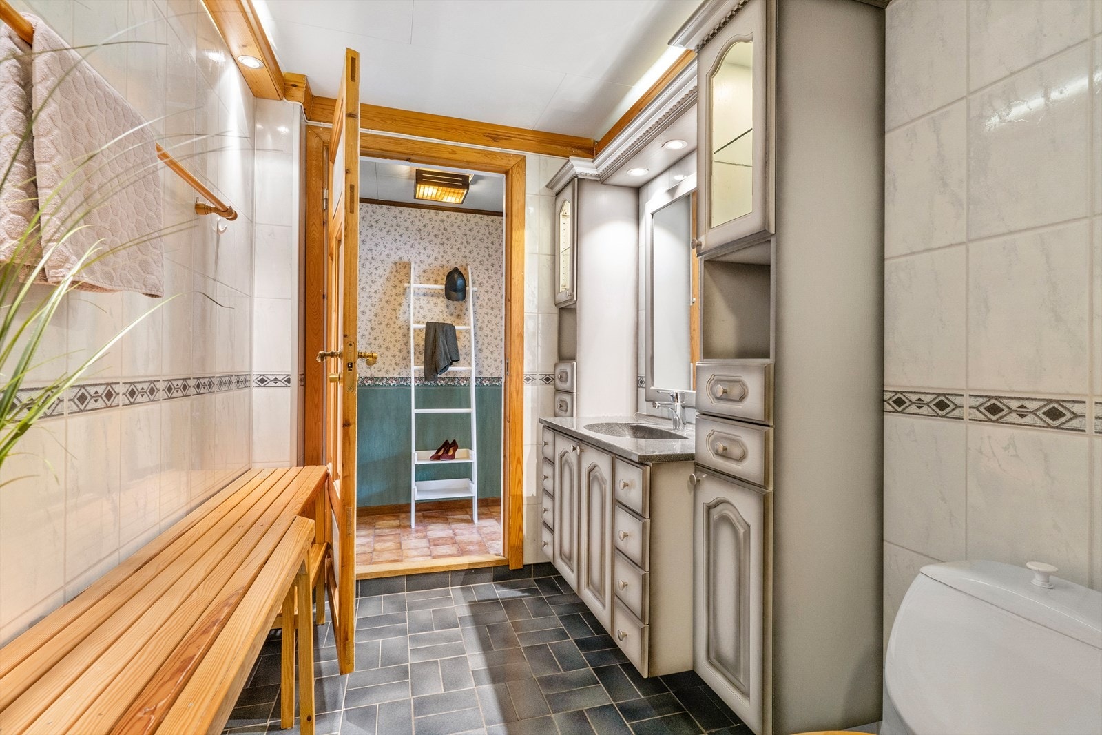 Himling er belagt med takessplater, vegger er belagt med baderomspanel, med sokkelflis og gulvet er belagt med fliser. Galleribilde