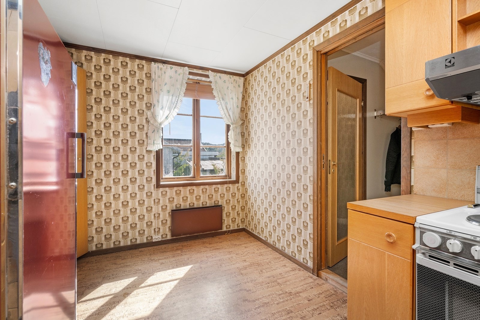 Kjøkkenet er av ukjent alder. Antas 70/80 tallet. Kjøkkeninnredningen har glatte fronter, laminert benkeplate, vaskekum i stål, komfyr, ventilator og kjøleskap. Galleribilde