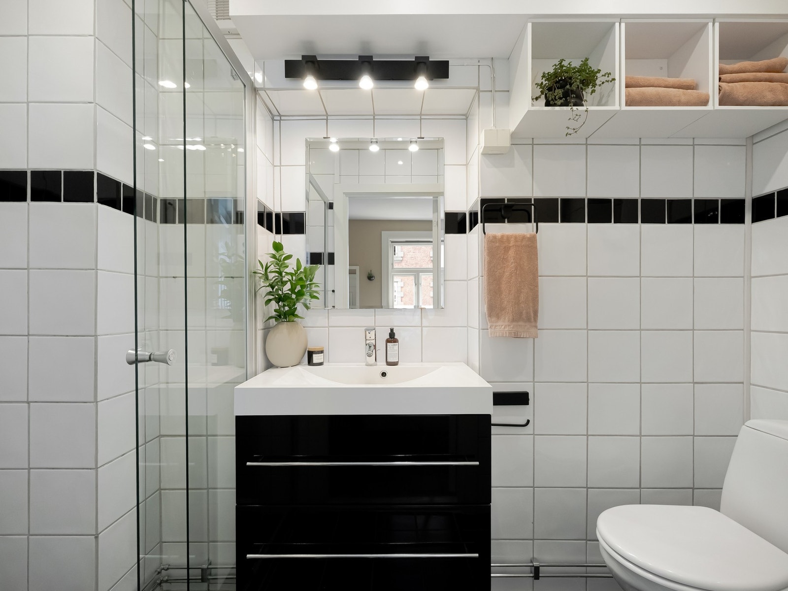 Det er innredet med dusjsone med skyvedør i glass, servantskap med oppbevaring i skuffer og gulvstående toalett. Galleribilde