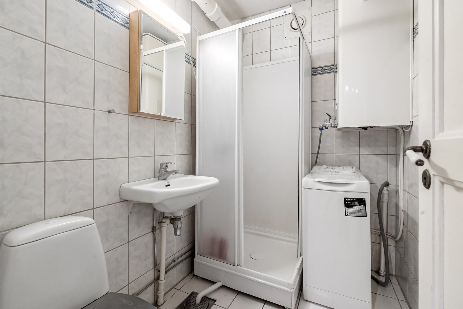 Eldre, flislagt baderom med opplegg for vaskemaskin. Galleribilde