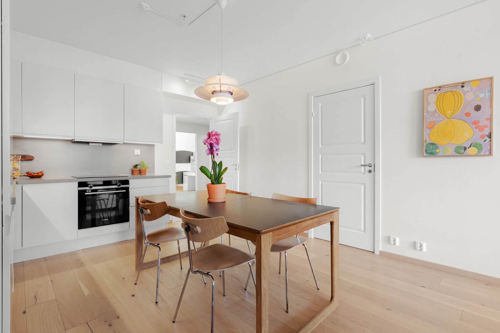 Moderne kjøkken med hvite skap, grå benkeplate og integrerte hvitevarer. Galleribilde