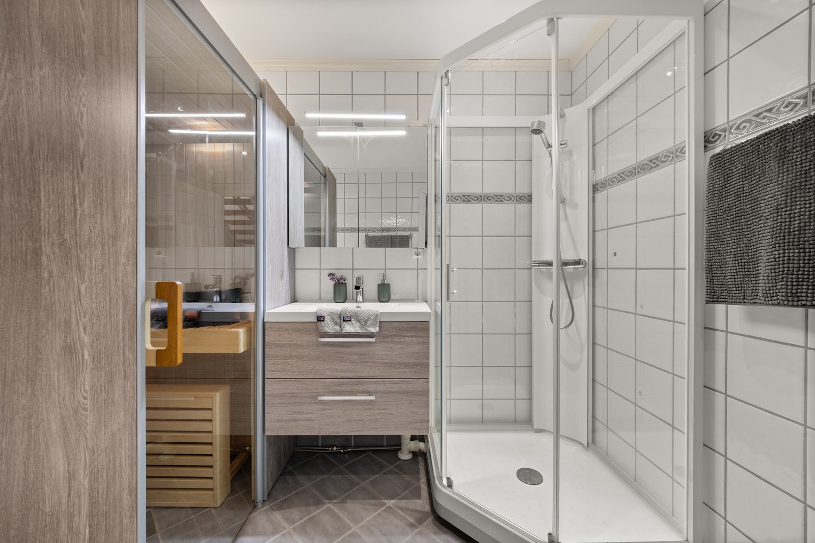 Flislagt bad med moderne innredning, vegghengt toalett med enkel servant Galleribilde