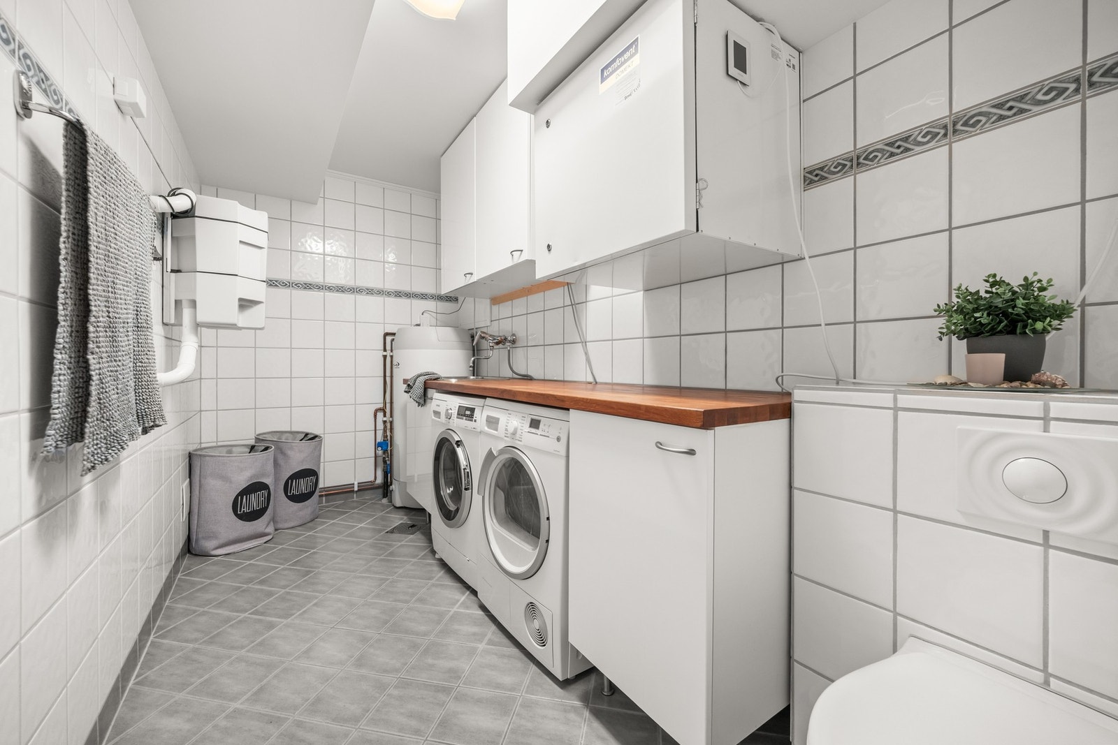 Eget vaskerom med rikelig benkeplass og opplegg for vaskemaskin og tørketrommel - dette medfølger salg Galleribilde