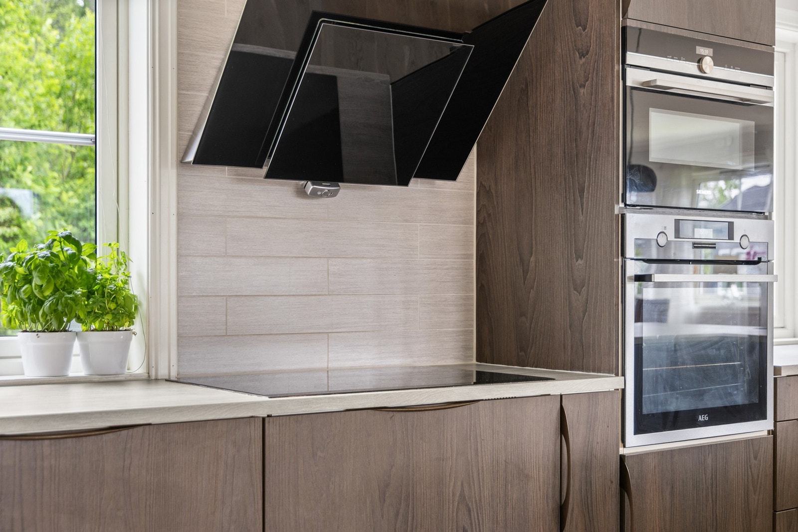 Det er integrert stekeovn, mikrobølgeovn, vinkjøler og oppvaskmaskin Galleribilde