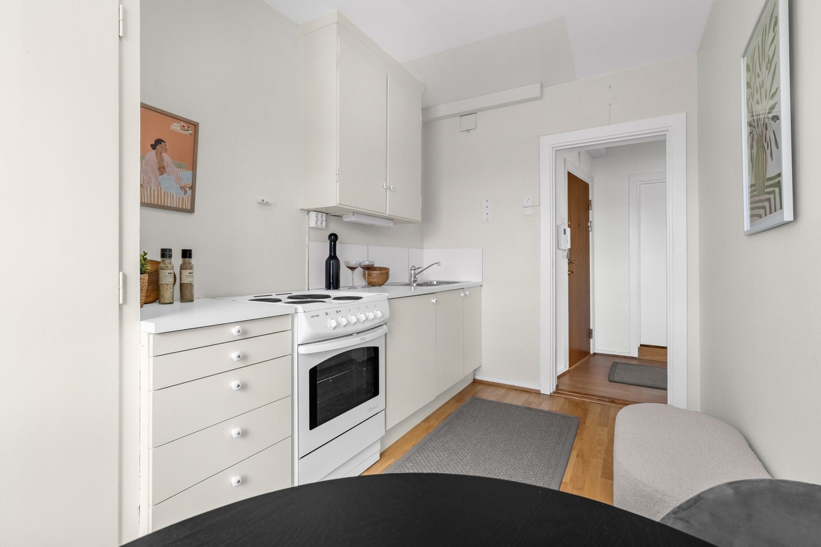 Eldre kjøkkeninnredning, med glatte fronter, og laminat benkeplate med nedfelt kum i rustfritt stål. Galleribilde